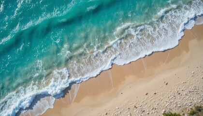 View from above of turquoise ocean waves gently lapping against a white sand beach with seashells all over the place and a colorful coastal scenery