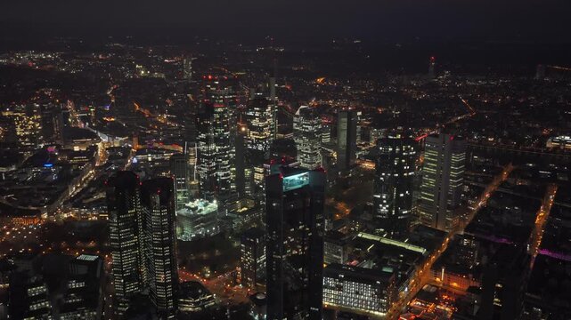 Frankfurt skyline glowing at night with an aerial view of financial district. Modern architecture and skyscrapers like Trianon illuminate city