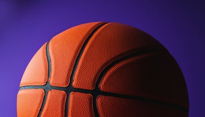 Close-up of an orange basketball against a vibrant purple background