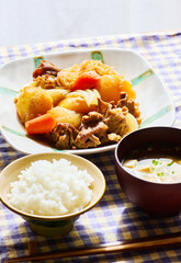 Japanese Nikujaga Meal with Rice and Miso Soup on Checkered Tablecloth