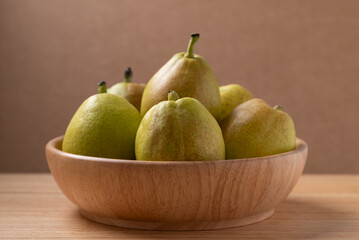 Fresh pear in a bowl on wooden background