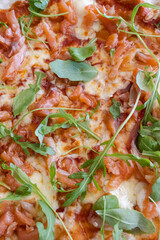 Pizza with smoked salmon, mozzarella, and arugula