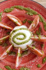 Caprese salad with mozzarella, tomato wedges, and pesto sauce