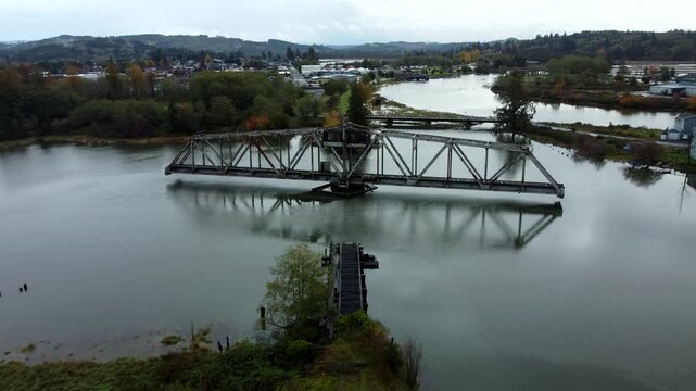 US, WA, Raymond, 2025-10-25 - Drone view of the abandoned train trestle rotating bridge on the Willapa River