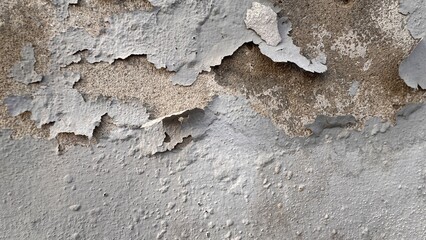 Rough damaged wall with peeling plaster exposing underlying brown surface creating natural weathered textures ideal for grunge and construction backgrounds on white background