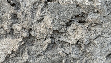Closeup of rough grey concrete wall showing deep vertical crack with gritty textured surface ideal for construction defect and grunge backgrounds on white background
