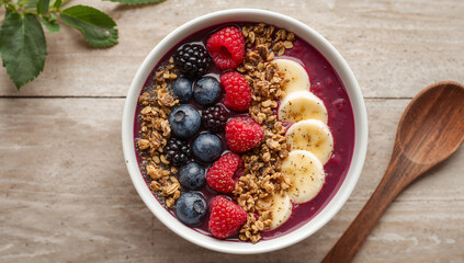 Fresh breakfast bowl with smoothie, banana, granola, and berries in a clean, sunny environment.