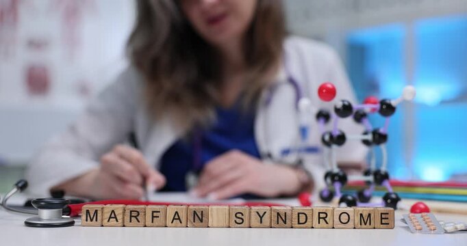Text Marfan Syndrome of wooden blocks with pills and stethoscope on doctor workplace. Genetic disorder causes people to have unusually long limbs