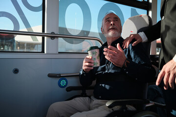 Man with coffee inside public bus receiving assistance