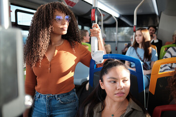 Young diverse women commuting on public transport bus
