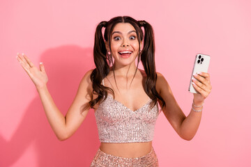 Happy young woman with pink background taking a selfie in a sequined top and skirt