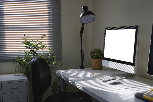 Side view workspace featuring a computer monitor, desk lamp, and office supply elements - Powered by Adobe