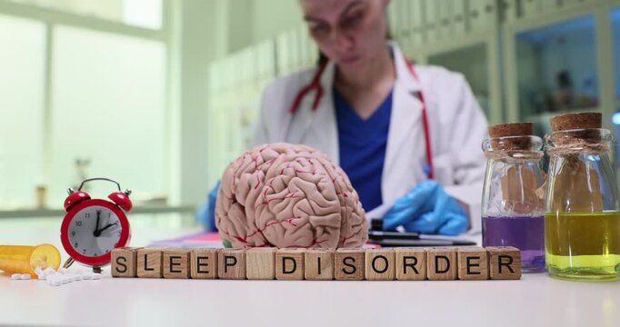 Text Sleep Disorder of wooden cubes by human brain model alarm clock and medications in hospital. Woman doctor works on patient diagnosis in office