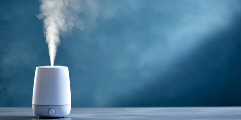 Fototapeta premium Modern white ultrasonic humidifier emitting visible mist on gray surface with blue blurred background