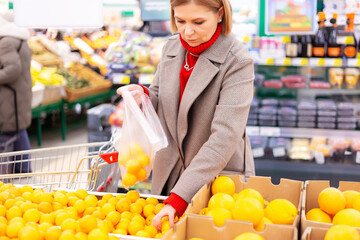 A beautiful middle-aged Caucasian woman is shopping in a supermarket.