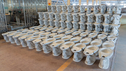 Neatly arranged sanitary ceramic components in a ceramic toilet production workshop