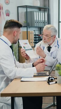 Likable experienced successful senior bearded head doctor holding conference with qualified diverse medical colleagues and explaining them results of dna researches in boardroom
