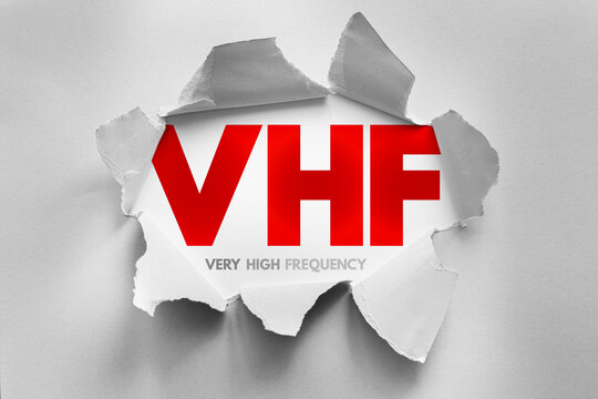 VHF acronym for Very High Frequency displayed beneath ripped paper effect, representing communication technology, radio transmission, broadcasting, signal range, and wireless data systems