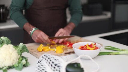 Professional male chef slicing fresh peppers in a modern kitchen - Powered by Adobe