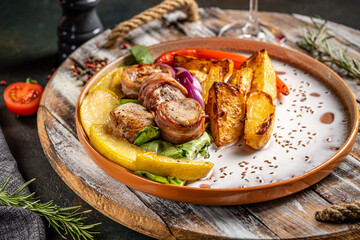 Bacon wrapped meat rolls with roasted potatoes