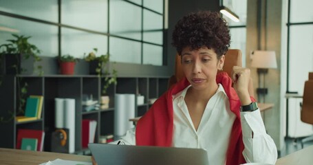 Gray suited woman pauses as she handles complex assignments diligently