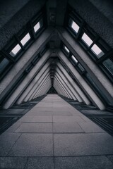 capitulating. Architectural tunnel with converging lines and fading natural light, perspective receding into darkness. real-estate listings.
