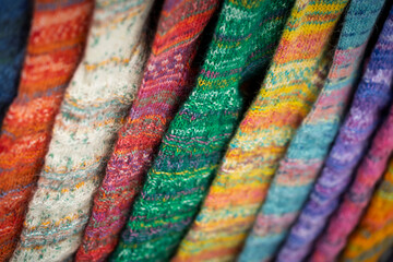 Close-up of colorful hand-knitted socks arranged in a row, showcasing their varied patterns and textures.