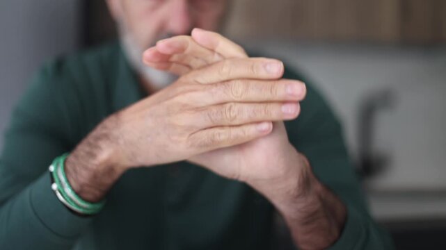 Mature man cracking his knuckles and stretching his fingers