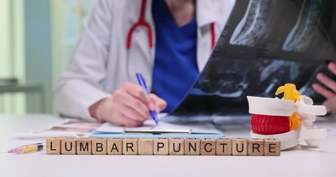 Lumbar Puncture phrase on wooden cubes and doctor holds x-ray images in hospital. Collect sample of cerebrospinal fluid from lower spine to examine
