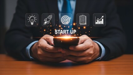 Businessman in suit uses smartphone with "START UP" text and icons representing ideas, launch, goals, tasks, and growth.