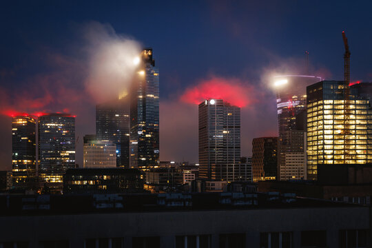 Modern city skyline at night with fog and lights