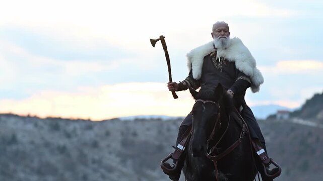 A Viking warrior draped in fur rides a powerful black horse across a vast landscape at sunset. The moment captures the raw spirit of ancient adventure and wilderness in a cinematic slow-motion style