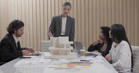 Architects and designers collaborate on an eco-friendly building project, discuss sustainable design elements and 3D architectural model. Planning energy-efficient solutions to reduce carbon footprint