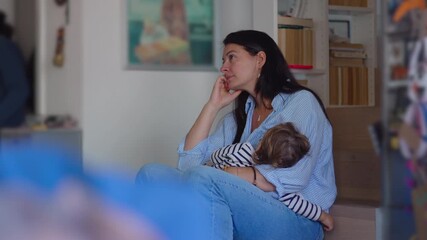 Mother breastfeeding sleeping toddler while sitting quietly in reflective mood creating calm intimate moment blending nurturing care with soft emotional stillness inside warm family home