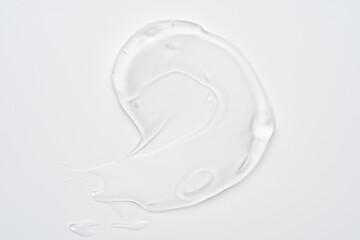 Pure transparent cosmetic gel smear on white background, skin care glycerin texture. top view.