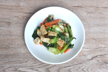 fried Kailaan Chinese kale and carrot with tofu dressing soy sauce vegetarian food on plate