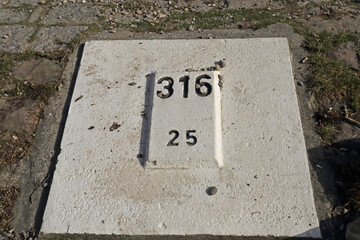 Kilometerstein am Ufer des Rheins