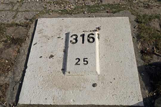 Kilometerstein am Ufer des Rheins