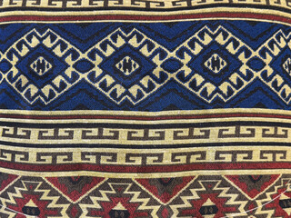 Traditional ethnic fabric cloth in random ornate diamond shape and lace, and abstract paisley decorative ornamental pattern, in blue and red color. Seamless background texture.