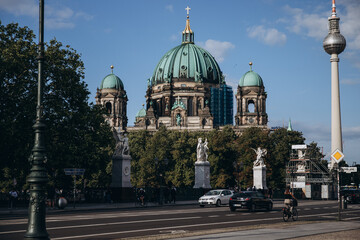Berlin Cathedral and TV Tower amidst bustling city life.
