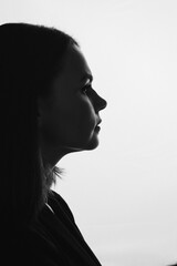 Black and white side profile portrait of a woman in silhouette.