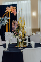 Elegant wedding reception table setting with floral arrangements and candle centerpieces.