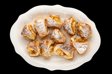 Fragrant mini strudels with apples on a black background, close-up.