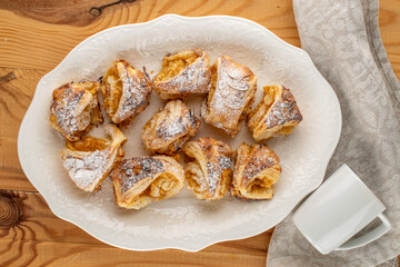 Fragrant mini strudel with apples on a white ceramic dish, top view. macro.
