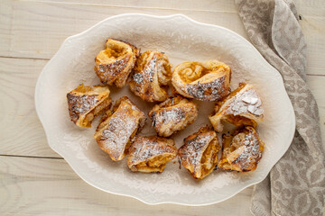 Fragrant mini strudel with apples on a white ceramic dish, top view. macro.
