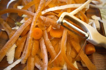 Carrot peel with a vegetable peeler in close-up, showing organic kitchen waste for composting and recycling.