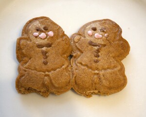 2 baked gingerbread human figures stuck together symbolizing Christmas, love, friendship and togetherness.