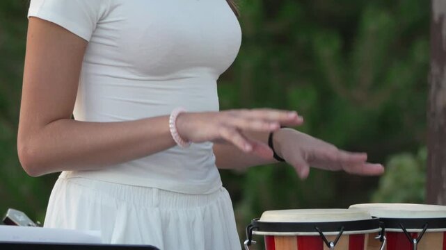 Bongo, Drummer, Music: Young woman performing on bongo drums outdoors
