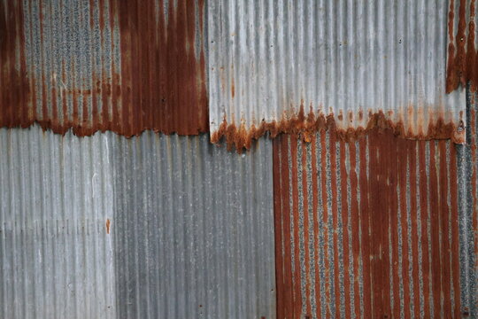 Artistic of old and rusty zinc sheet wall. Vintage style metal sheet roof texture. Pattern of old metal sheet. Rusting metal or siding. Corrosion of galvanized. Background and texture in retro concept