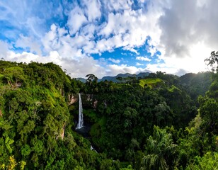 Majestic waterfall cascading through lush green jungle under a cloudy sky